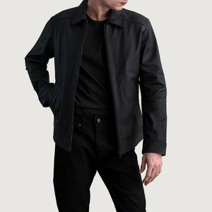 Person wearing a black jacket and pants on a light gray background