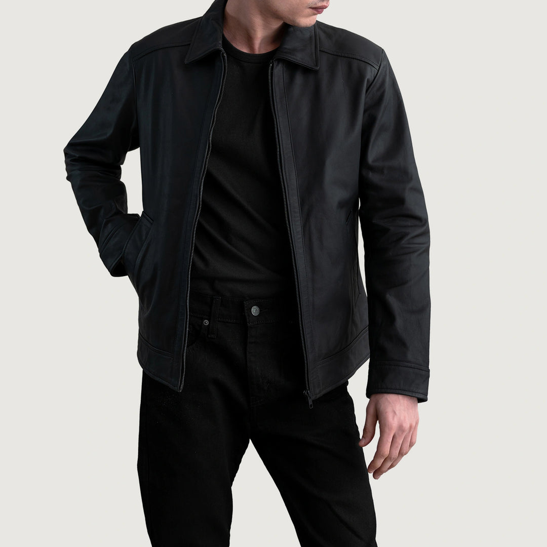 Person wearing a black jacket and pants on a light gray background